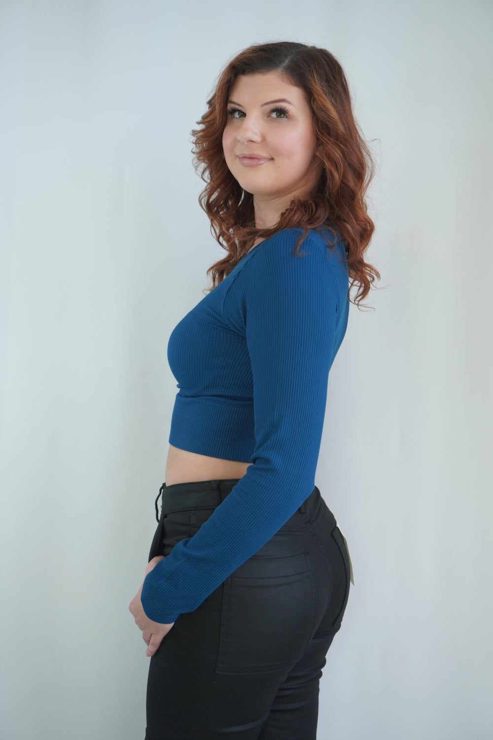Side view of fitted teal long-sleeve crop top