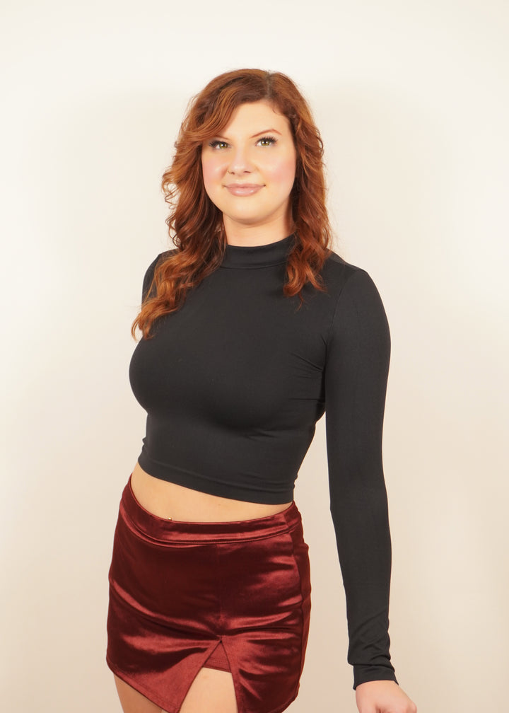 Black long-sleeve cropped top with high neckline and fitted silhouette