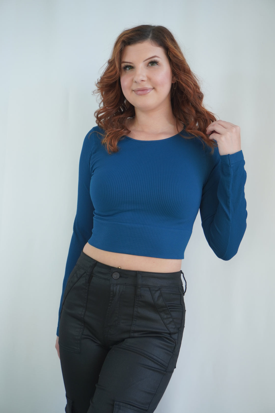 Deep teal long-sleeve ribbed crop top with rounded neckline and fitted design